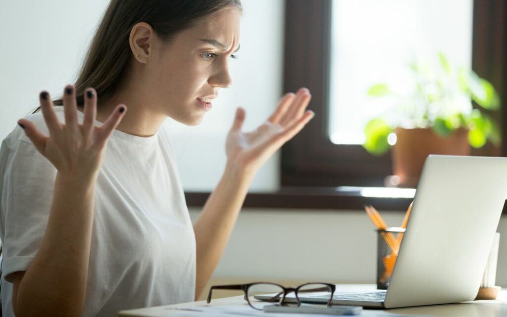Femme énervée devant son PC trop lent — comment rebooster un ordinateur