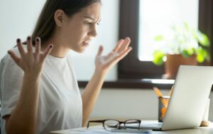 Femme énervée devant son PC trop lent — comment rebooster un ordinateur
