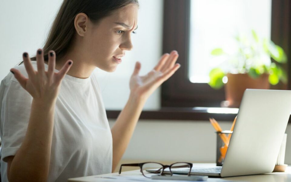 Femme énervée devant son PC trop lent — comment rebooster un ordinateur